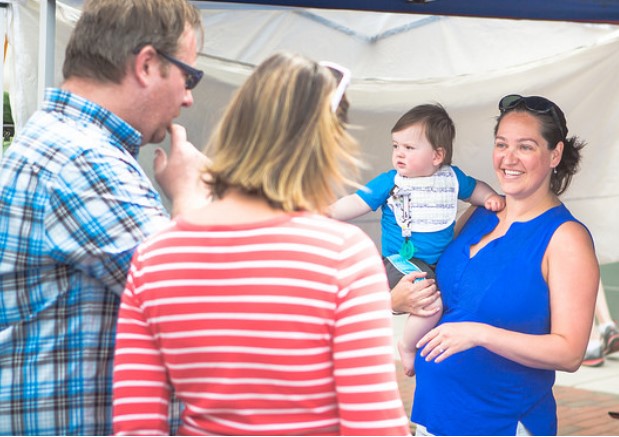 Angie with baby Owen at a town event helping visitors